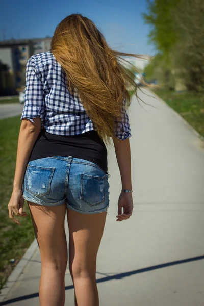 Dívka v šortkách, jízda na skateboardu — Stock fotografie
