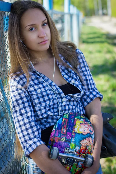 Porträtt av en tjej i shorts med skateboard — Stockfoto
