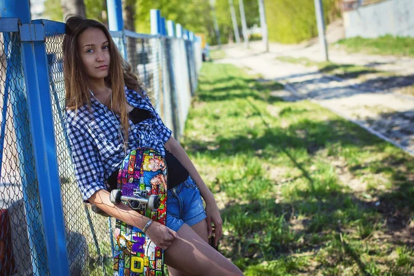 Portret van een meisje in korte broek met skateboard — Stockfoto