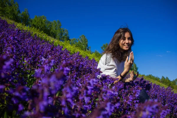 Dívka sedící na květinová louka — Stock fotografie