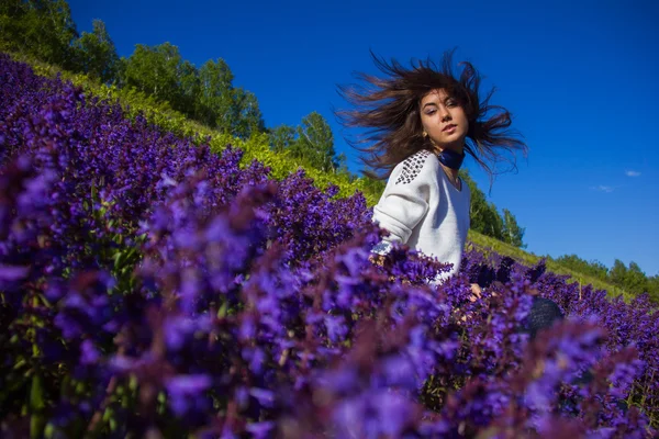 Dívka sedící na květinová louka — Stock fotografie