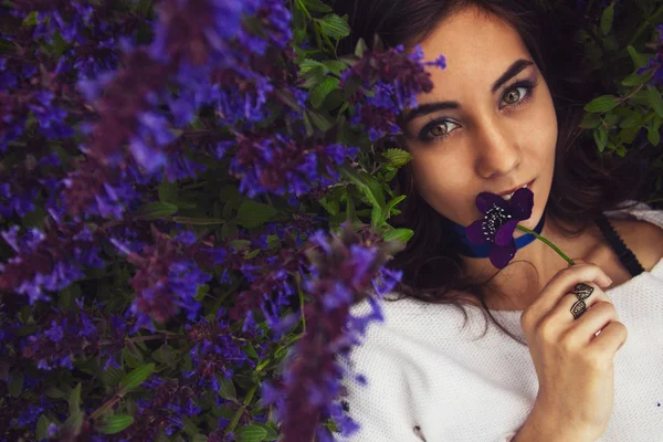 Ritratto di una ragazza sdraiata su un prato di fiori — Foto Stock