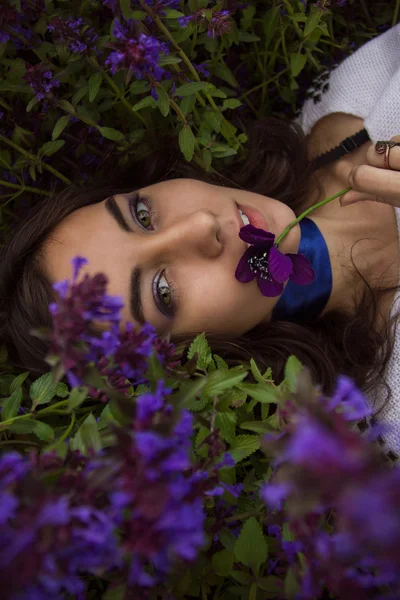 Ritratto di una ragazza sdraiata su un prato di fiori — Foto Stock