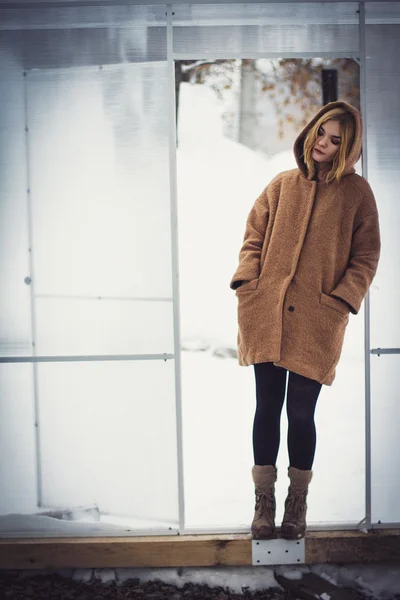 Het meisje in de jas in de serre — Stockfoto