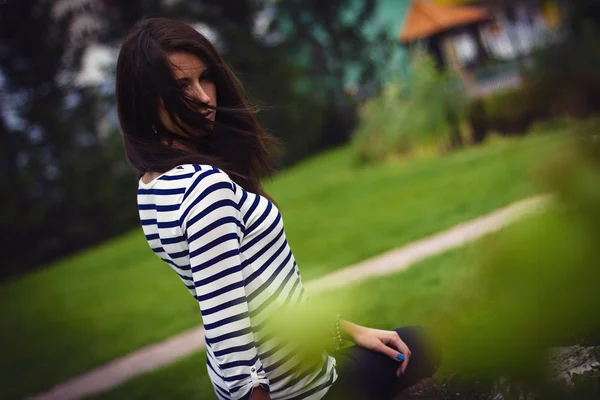 Menina em uma t-shirt está sentado em uma rocha — Fotografia de Stock