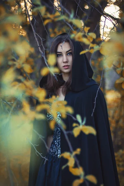 La fille au manteau noir dans la forêt — Photo