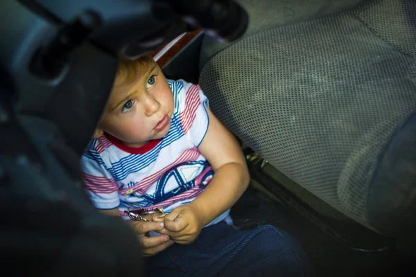 Liten pojke sitter i bilen — Stockfoto