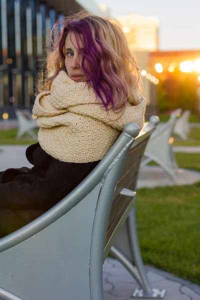 The girl in the coat sitting on the bench — Stock Photo, Image