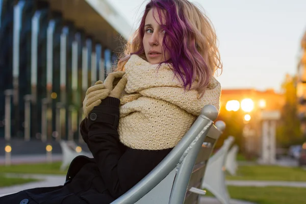 La fille dans le manteau assise sur le banc — Photo