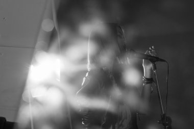 bir stüdyoda bir mikrofona şarkı söyleyen kız