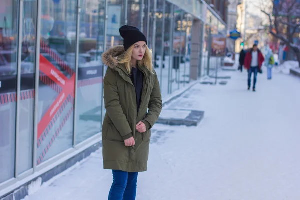 The girl zipping up his jacket on the street — Stock Photo, Image