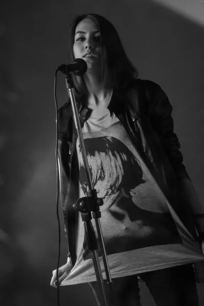 Bir stüdyoda bir mikrofona şarkı söyleyen kız — Stok fotoğraf