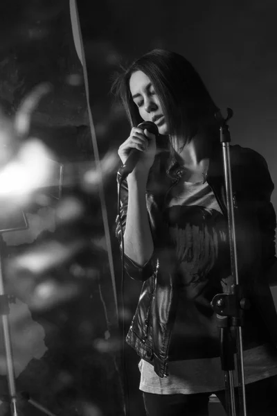 Menina cantando em um microfone em um estúdio — Fotografia de Stock