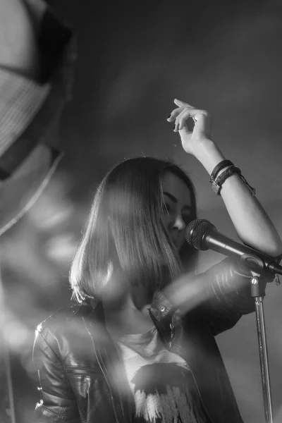 Dívka zpívat do mikrofonu v ateliéru — Stock fotografie