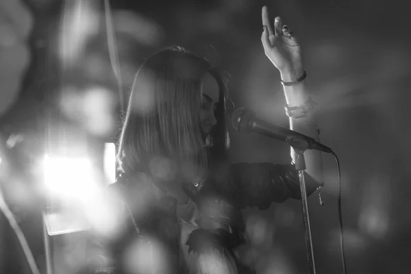 Girl singing into a microphone in a studio — Stock Photo, Image