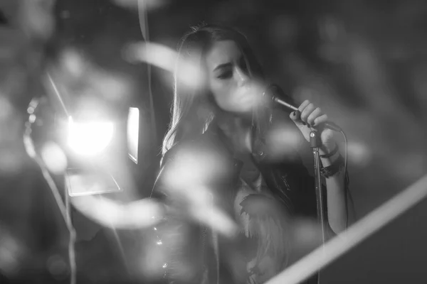 Girl singing into a microphone in a studio — Stock Photo, Image