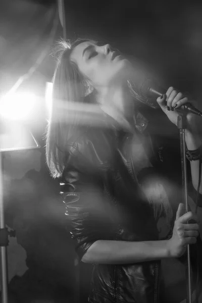 Menina cantando em um microfone em um estúdio — Fotografia de Stock