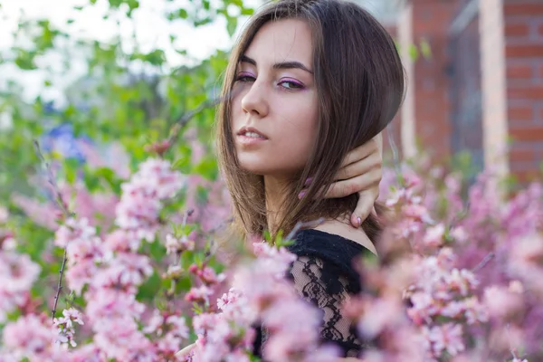 Retrato de menina bonita jovem em flores — Fotografia de Stock