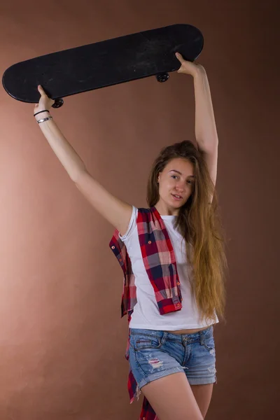 Porträtt av en flicka med en skateboard i studion — Stockfoto