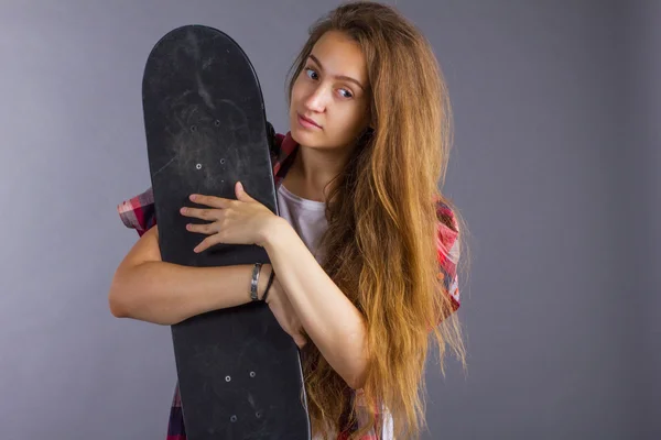 Portrait of a girl with a skateboard in the Studio — Stock Photo, Image