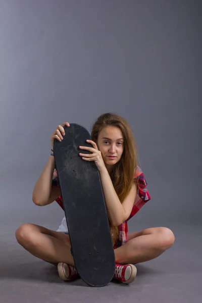 スタジオでスケート ボードを持つ少女の肖像画 — ストック写真