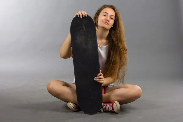 Ritratto di una ragazza con uno skateboard nello Studio — Foto Stock