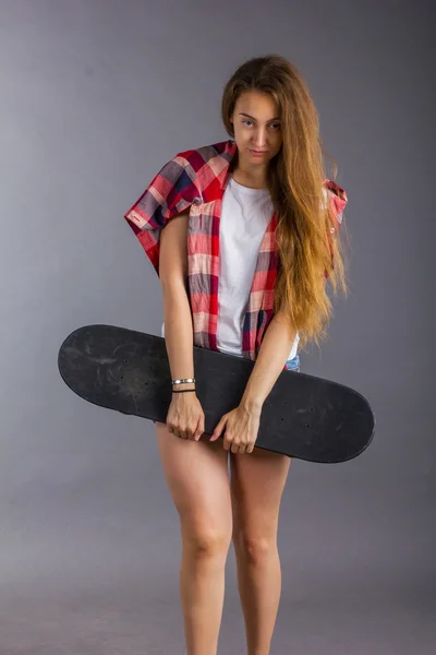 Retrato de uma menina com um skate no estúdio — Fotografia de Stock