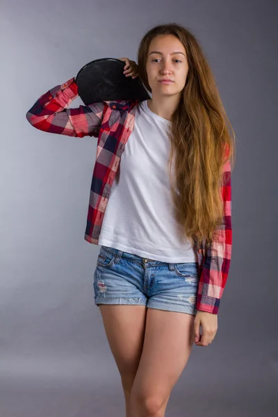 Retrato de uma menina com um skate no estúdio — Fotografia de Stock