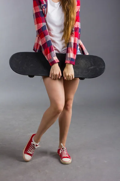 Retrato de uma menina com um skate no estúdio — Fotografia de Stock