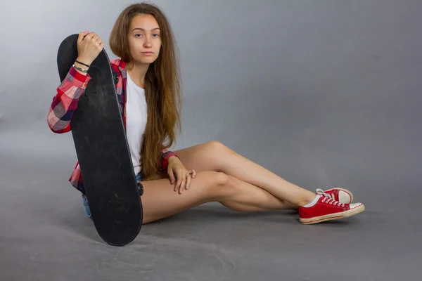 Ritratto di una ragazza con uno skateboard nello Studio — Foto Stock