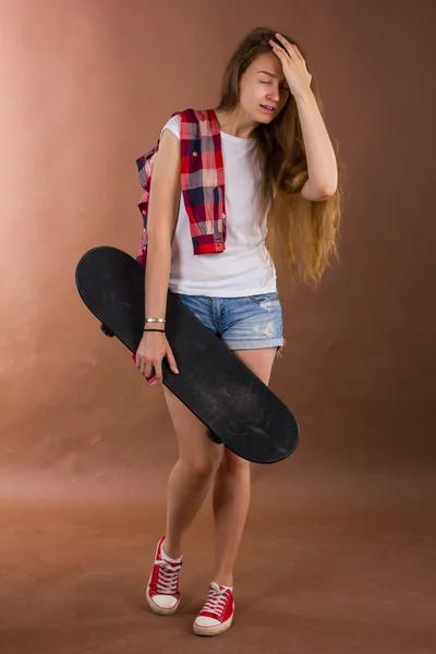 Portrait of a girl with a skateboard in the Studio Stock Image