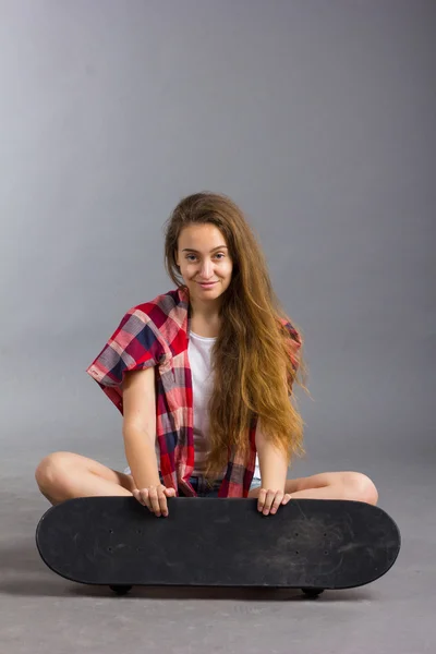 Portrait of a girl with a skateboard in the Studio Stock Picture