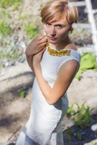 Vacker ung blondin i en vit klänning — Stockfoto