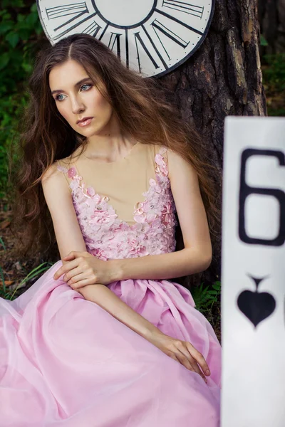 Porträt eines jungen Mädchens in einem rosafarbenen Kleid als Alice im Wunderland — Stockfoto