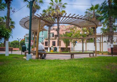 Emekli olmuş insanlar parkta oturuyorlar.