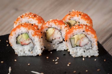 Suşi Japon yemeği. Ton balığı, somon, karides, yengeç ve avokado. Suşi çeşitliliğinin en üst görüntüsü. Gökkuşağı suşi rulosu.