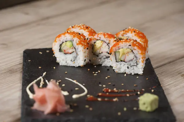 Suşi Japon yemeği. Ton balığı, somon, karides, yengeç ve avokado. Suşi çeşitliliğinin en üst görüntüsü. Gökkuşağı suşi rulosu.