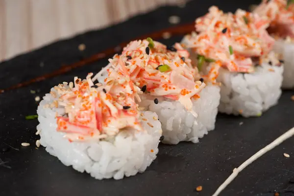 Suşi Japon yemeği. Ton balığı, somon, karides, yengeç ve avokado. Suşi çeşitliliğinin en üst görüntüsü. Gökkuşağı suşi rulosu.