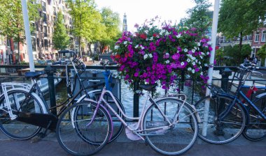 Amsterdam / Hollanda - 03 Ağustos 2018: Bisikletler ve antik mimari ile süslenmiş Amsterdam kanallarının manzarası. Amsterdam kanallarının manzarası çok güzel..