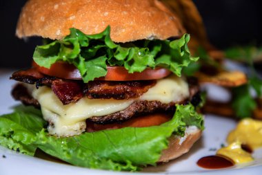 Sebzeli büyük bir burgerin yakın çekimi.