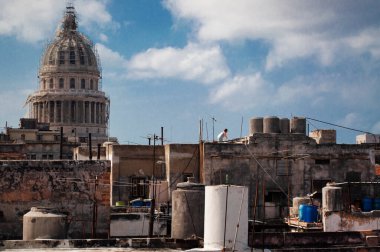 Evlerin ve insanların yaşadığı eski ve yıkık dökük bir şehirde çatıdaki bir insanın havadan panoramik görüntüsü. Havana Küba