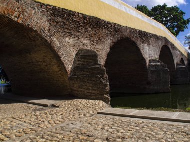 Nehirden geçen antik taş köprü, kaldırım taşı caddesi, ortaçağ şehri, güneşli bir gün.