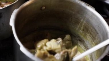 Yemek hazırlamak, malzemeleri karıştırmak ve eti metal bir kapta çeşnilendirmek. Mutfakta yemek pişirmek.