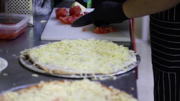 Krojenie Pomidorów Metalowym Nożem Białej Desce Krojenia Obok Kawałków Pizzy — Wideo stockowe