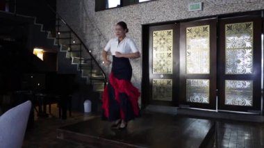 İspanyol flamenko dansçısı bir restoranın içindeki tahta bir sahnede dans ediyor. Genç kız.