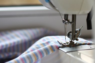 dikiş makinesi ve çizgili kumaş için bir yaprak