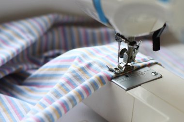 dikiş makinesi ve çizgili kumaş için bir yaprak