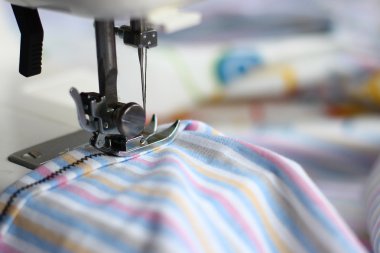 dikiş makinesi ve çizgili kumaş için bir yaprak