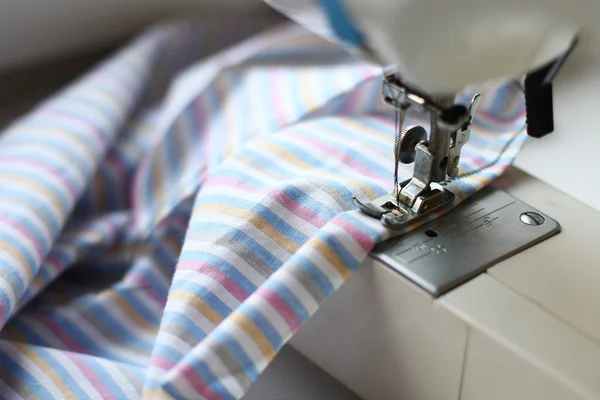 The sewing machine and striped fabric for a sheet — Stock Photo, Image
