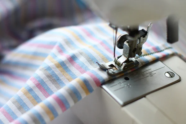 The sewing machine and striped fabric for a sheet — Stock Photo, Image